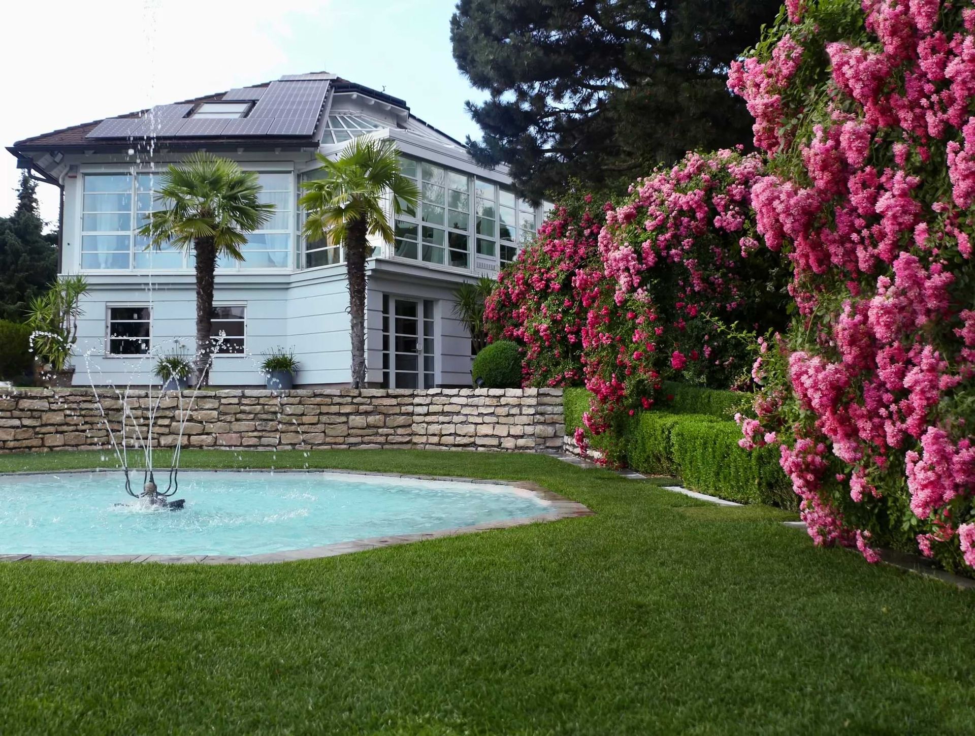 Haus mit Springbrunnen und Garten